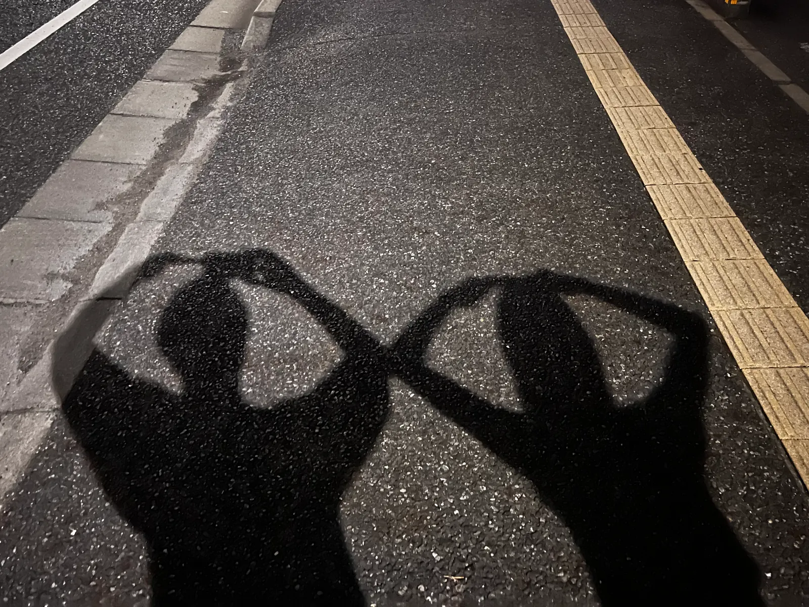 夜晚人行道上,並肩的兩人身影
